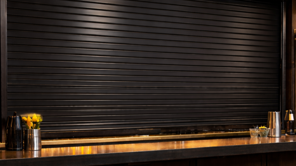 Black servery bar roller shutter installed behind a professional counter