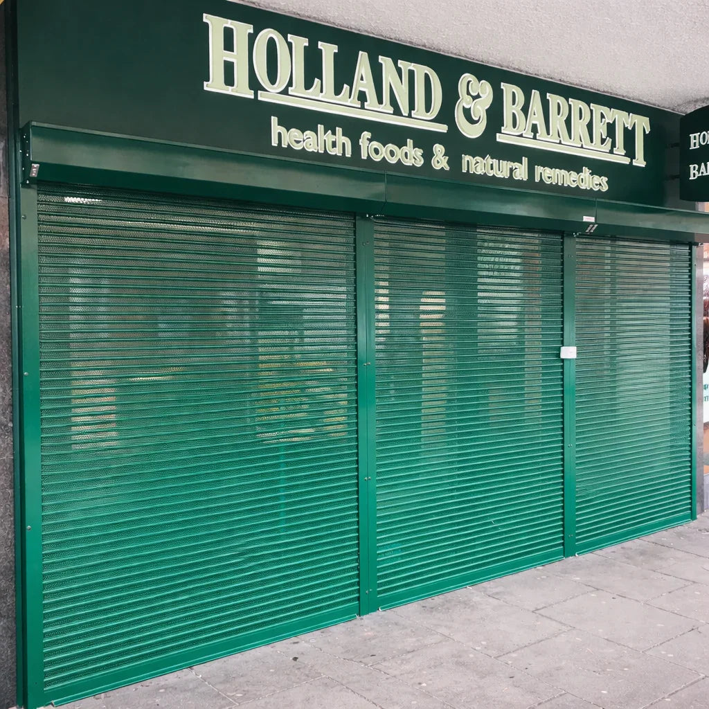 Green roller shutters securing a Holland & Barrett store front