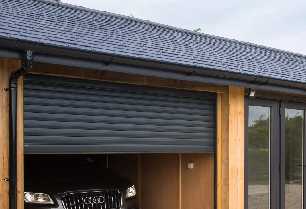 Black roller garage door on wooden shed with car inside, security-focused design
