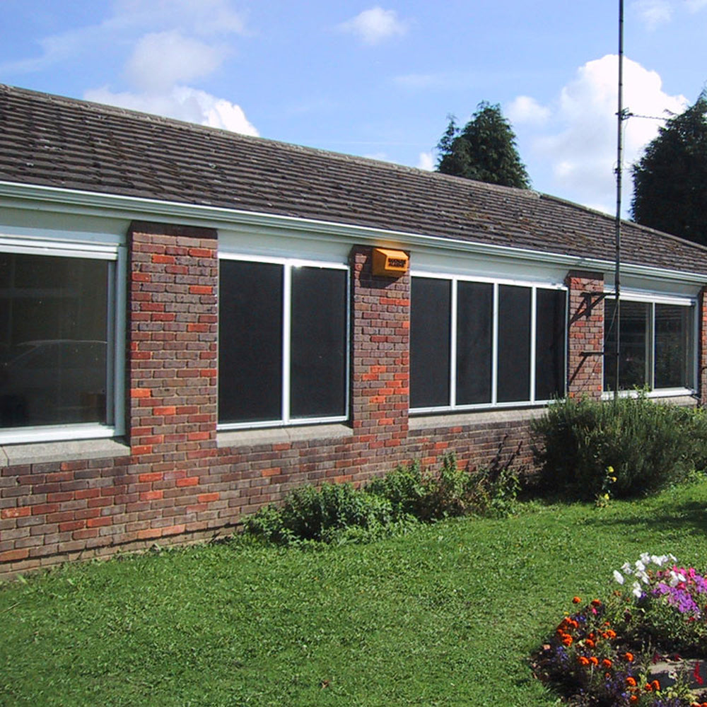 CrimeShield Perforated Window Security Mesh installed on a brick building