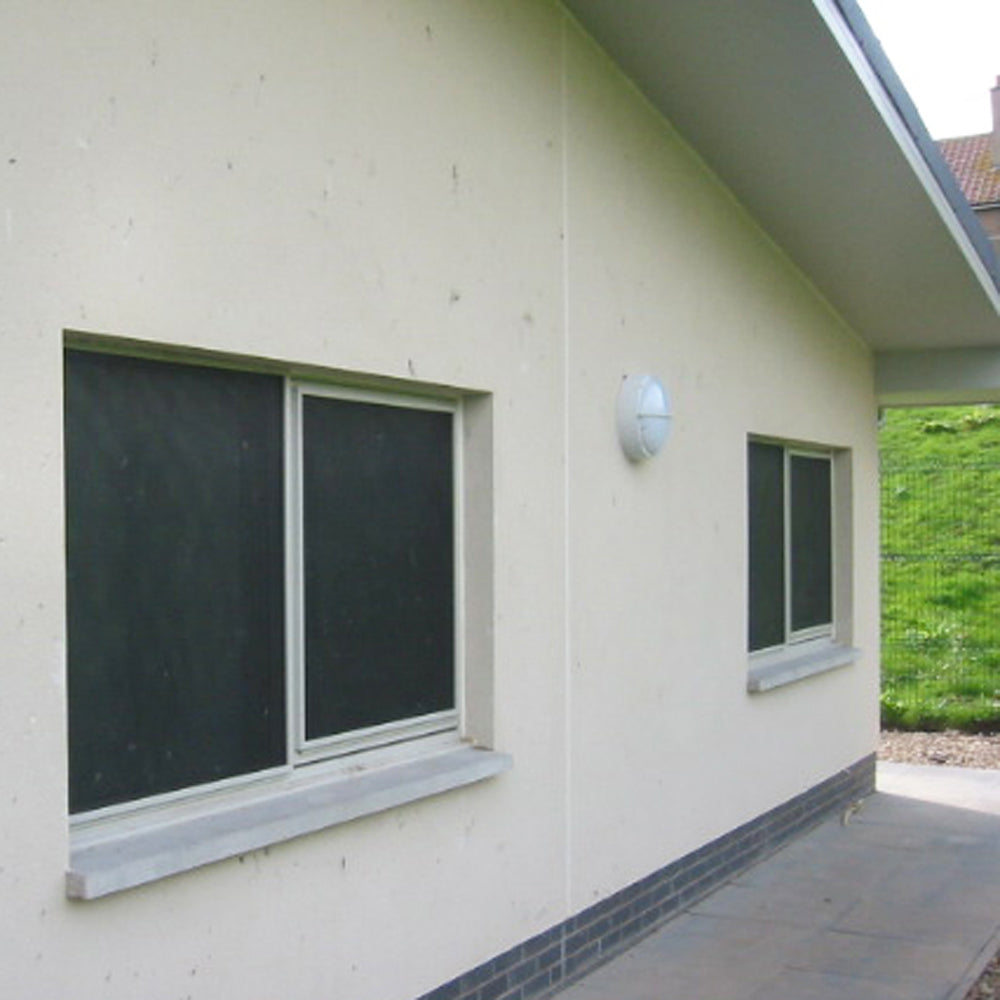 CrimeShield perforated window security mesh installed on a light-colored building exterior
