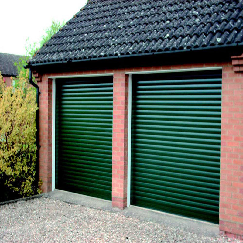 Two dark green roller shutter doors installed on a red brick garage building.
